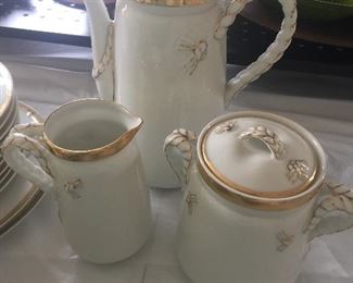 A Limoges pot with cream and sugar set appears to have gold braided handles. 