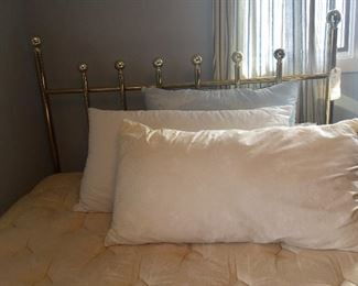 A brass-finish bed and fluffy pillows are sure to be just right for someone.