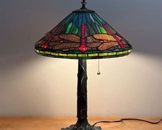 TIFFANY-STYLE DRAGONFLY LAMP | Tiffany-style stained glass lamp, dragonflies with "jewel" bead eyes, on a cast metal base with viney lily pads, two lights with pulls
Dimensions: h. 24 x dia. 17 in.