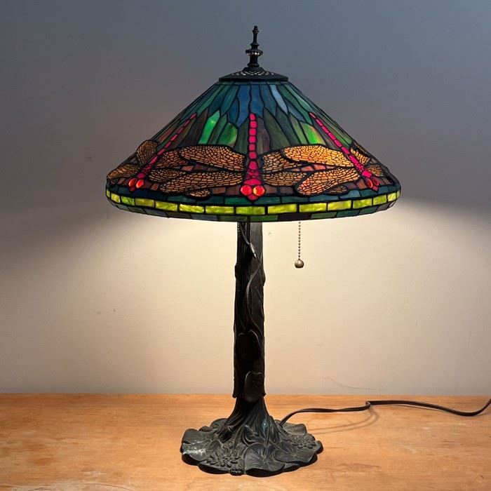 TIFFANY-STYLE DRAGONFLY LAMP |  Tiffany-style stained glass lamp, dragonflies with "jewel" bead eyes, on a cast metal base with viney lily pads, two lights with pulls
Dimensions: h. 24 x dia. 17 in.