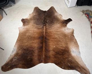 SADDLEMANS STEER HIDE RUG | Free-form cow hide rug, brown with stripes and marked with brand and other labeling on the bottom
Dimensions: 89 x 79 in.