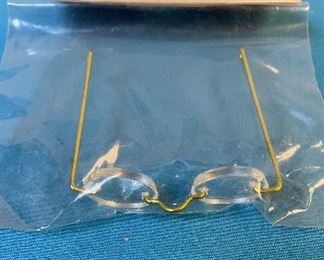 Doll Eye Glasses and Overall Buckles. Assortment of eyeglasses for dolls, and overall buckles for dolls.