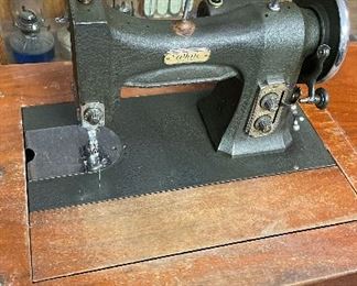 White Rotary Sewing Machine. White Rotary Sewing Machine in wooden cabinet with drawers.