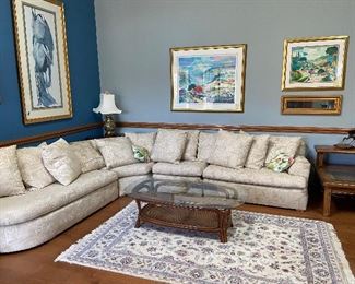 lovely den overview with 4-piece sectional sofa, artwork, rattan glass top table, rug
