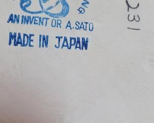 label on seated man with hawk figurine