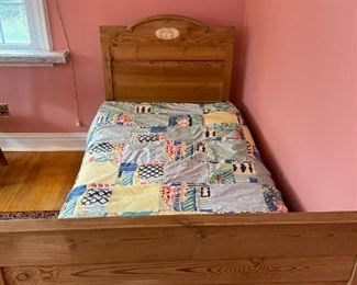 Wooden twin bed with bedding and mattress