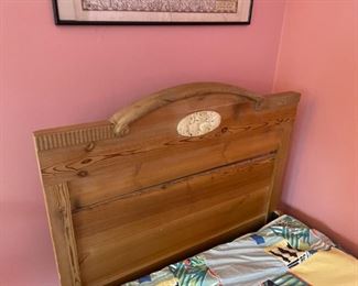 Wooden twin bed with bedding and mattress