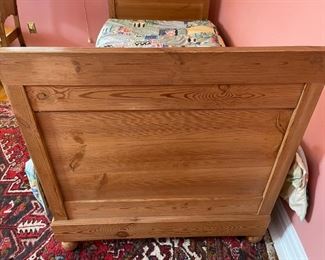 Wooden twin bed with bedding and mattress