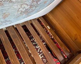 Wooden twin bed with bedding and mattress