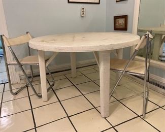 Rounded white table with two metal matching chairs