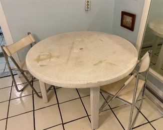 Rounded white table with two metal matching chairs
