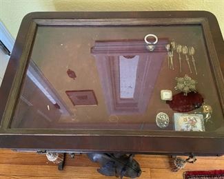 Display glass top wooden table with pull drawer, one shelf 
Collection of pig figurines in ceramic, stone and metal