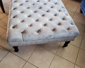 Light grey tufted ottomon with silver studs
With wheels
34x34x18