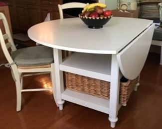 Near perfect condition drop leave pottery barn table with two matching chairs.
