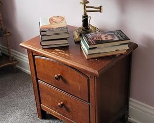 Two-drawer end table and lamp.  Books