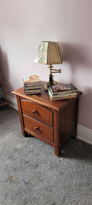 Two-drawer end table and lamp.  Books