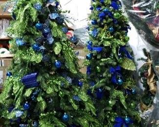 Many pre-decorated christmas trees, sold as-is