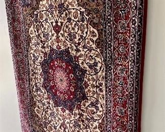 An absolutely stunning Isfahan Persian rug hanging on the wall.  It doesn’t get any nicer!  Signed in Arabic on  the fringe edge.