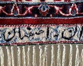 An absolutely stunning Isfahan Persian rug hanging on the wall.  It doesn’t get any nicer!  Signed in Arabic on  the fringe edge.