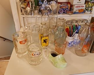 Collection of vintage advertising milk bottles and glassware mugs