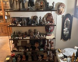 This bookcase shows off the various decorative masks and multiple figurines from Asian, African, Meso-American, Native American, and other cultures.
