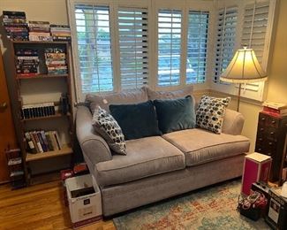 Here you can see another loveseat sofa, stand lamp, and a bookcase for your collections.