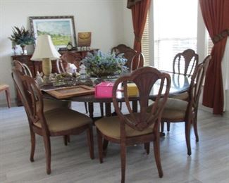 A buffet all inlay with gorgeous round dining table drop leaves very unique. 10 matching chairs. Custom Glass top!