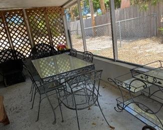 Wrought iron glass top table, 6 chairs and a serving cart.