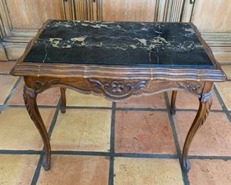 Graceful and wonderful dark wood carved table with heavy black marble top. Has crack in marble.