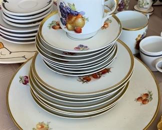 Set of dishes with fruit motifs and gold rims. 