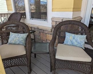 Two wicker chairs with small glass table.