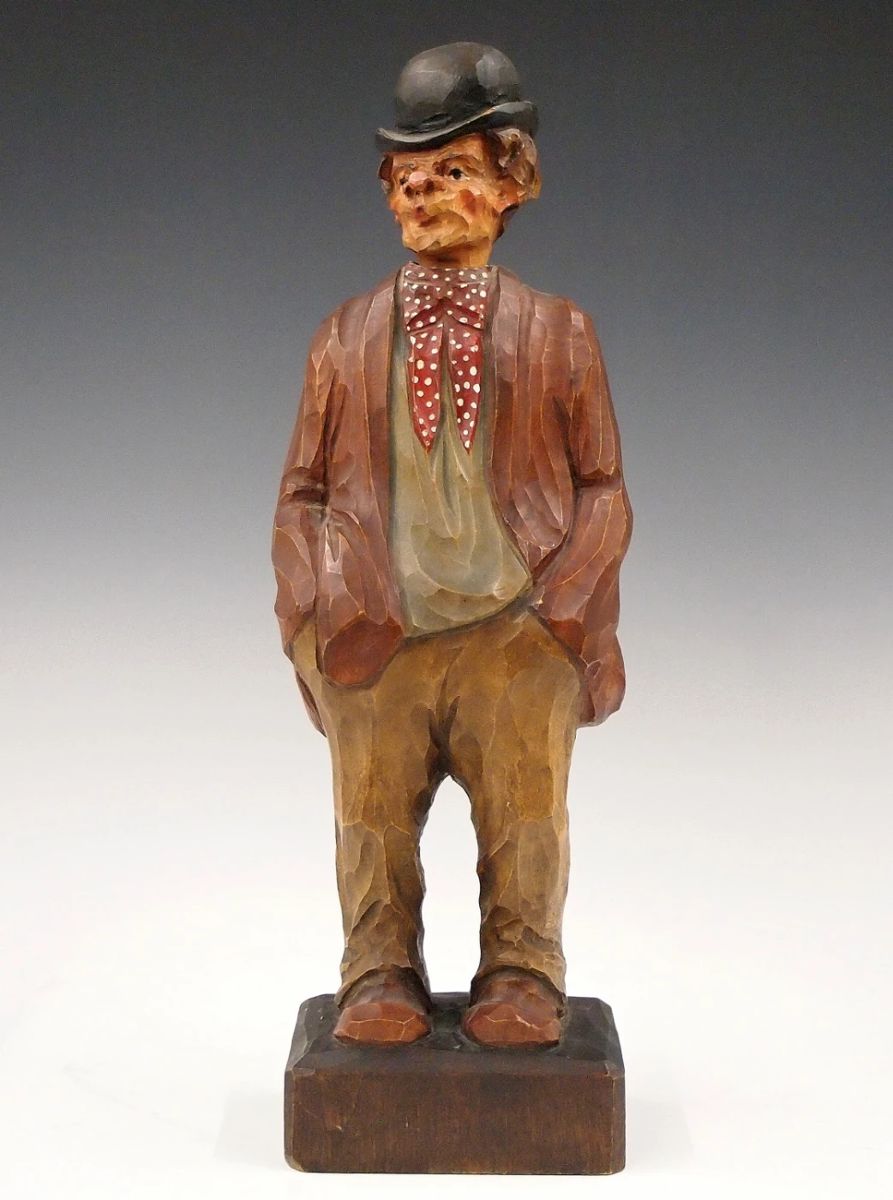 Lot 1: A mid 20th century German clockwork "Whistler" figure.  Carved wooden automaton figure whose head moves and whistles a tune when activated via Brass key wind movement with bellows.  Original painted finish.  Minor wear, working when cataloged.  13 1/4" high overall.  ESTIMATE $400-600
