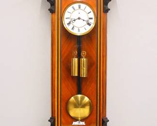Lot 3: A late 19th century Vienna Regulator wall clock by H. Endler & Co. Freiburg, Germany.  8-day weight driven time only movement with two part porcelain dial with Roman numerals, subsidiary seconds and molded Brass bezel, serial #101468.  Figured Walnut Biedermeier case with a stepped, arched crown and turned finials over a single long door with arched glass flanked by fluted pilasters with shaped detail over a shaped drop.  Older finish with Ebonized detail, minor wear, replaced top finial, running when cataloged.  47 1/2" high overall.  ESTIMATE $400-600
