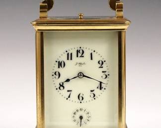 Lot 16: A late 19th century French Carriage clock, retailed by "J. Chrestin, Nice".  8-day movement with Petite Sonnerie strike and Grand Sonnerie repeat, porcelain dial with Arabic numerals and subsidiary alarm set dial.  Brass case with folding handle, molded top and base, and beveled glass panels.  Original leather covered travel case with sliding front panel.  Minor wear, running when cataloged, case with some damage, lacks carrying strap.  7 1/2" high overall.  ESTIMATE $800-1,200
