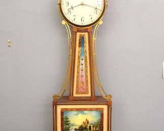 Lot 17: A 20th century Waltham model 904 Banjo clock.  8-day Brass, weight driven time only movement with Geneva stops marked "Waltham Watch Co. U. S. A." with painted Iron dial and Arabic numerals marked "Waltham".  Mahogany case with shaped Brass arms and Eagle finial, inlaid Brass "Rope" moldings, Brass dial door with convex glass over reverse painted throat and lower door glasses, shaped drop with fluted detail.  Original finish with minor wear, slight dial wear, running when cataloged.  40 3/4" high overall.  ESTIMATE $800-1,200
