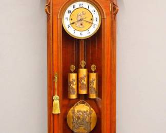 Lot 30: A 19th century German Regulator wall clock.  8-day weight driven time and strike movement with quarter hour Grand Sonnerie strike, Brass dial with porcelain chapter ring and Roman numerals, Silvered "Dancing Hours" appliques on dial, weights and pendulum.  Stamped "G P" trademark with a Knight on Horseback on movement.  Second Baroque Period Walnut case with carved scrolled crest and shaped molded cornice over an arched door flanked by molded pilasters and shaped lower drop with carved detail.  Restored finish with minor wear, damage and repair to chapter ring, minor loss to appliques on weights, running when cataloged.  46" high overall.  ESTIMATE $1,000-2,000
