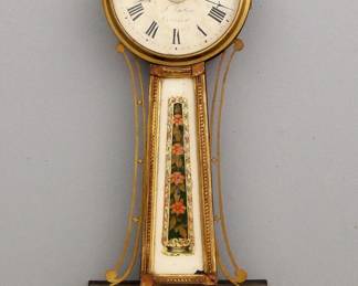 Lot 45: A 19th century American Banjo clock with alarm.  8-day Brass, weight driven time and alarm movement with exterior top mounted alarm bell, painted iron dial with Roman numerals.  Mahogany case with pierced Brass arms, Brass dial door with convex glass over reverse painted throat and lower door glasses.  Original Gilding with wear, replaced flat dial door glass and re-painted lower door glass, lacks some small Gilded decorations, running momentarily when cataloged.  33" high overall.  ESTIMATE $2,000-3,000
