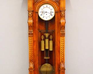 Lot 53: A Good 19th century Vienna Regulator wall clock by the Resch Brothers Clock Factory in Ebensee, Austria.  8-day weight driven time and strike movement with Grand Sonnerie quarter hour chime, two part porcelain dial with Roman numerals and fancy pullies and pendulum, rear plate with "Remember" Trademark, serial #80903.  Oversized Walnut case with arched crest and carved foliate detail over a long door with arched molded design, carved figural pilasters with Acanthus leaves and shaped lower drop with inlaid Burl panel and turned finials with carved detail.  Older finish with slight wear, running when cataloged.  64" high overall.  ESTIMATE $2,000-3,000
