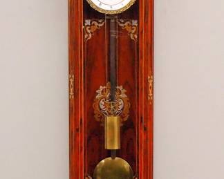 Lot 68:  A Very Good quality Inlaid Vienna Regulator wall clock by "J. Thiel, in Wien".  60-day weight driven time only movement with a flat porcelain dial, with visible escapement, cut Steel verge and subsidiary Day/Date dials, Roman numerals and Cast Piecrust bezel, marked "J. Thiel, in Wien".  Transitional Style Rosewood case with Brass, Copper and Pewter marquetry inlay features a carved crest above an arched carved crown with inlaid frieze, an arched door with chamfered corners and fluted columns with inlaid medallions, inlaid back panel and shaped inlaid drop and carved lower finial.  Finish in excellent condition with minor loose inlays, running when cataloged.  54 1/2" high overall.  ESTIMATE $4,000-6,000
