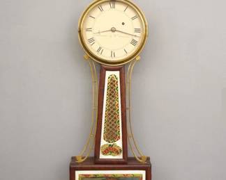 Lot 76: A mid 19th century American Banjo clock by William Cummens, Roxbury, Mass.  8-day time only movement with T-Bridge suspension and a painted Iron dial marked "Warranted by Wm. Cummens" with Roman numerals.  Mahogany case with a Brass Eagle on Urn finial over a molded Brass dial door, tapered throat panel with reverse painted glass flanked by shaped Brass side arms, lower door with a reverse painted glass.  Older finish with some wear, dial craquelure and some wear, replaced finial, crack in lower door glass, running when cataloged.  34 1/2" high overall.  ESTIMATE $3,000-4,000
