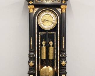 Lot 84: A 19th century Vienna Regulator wall clock.  30-day weight driven time and strike movement with engraved Brass dial and Silvered chapter ring with Roman numerals, molded Brass bezel.  Ebonized case with inlaid Brass, Pewter and Mother-of-Pearl decoration features a stepped arched crest over a with molded crown, inlaid floral frieze and an arched door with fluted tapered pilasters, carved detail and shaped drop with turned finials and inlaid panel.  Old finish with slight wear, some shrinkage, dial wear, running when cataloged.  56" high overall.  ESTIMATE $1,000-2,000

