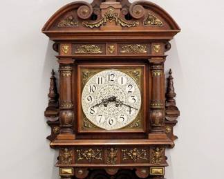 Lot 94: A late 19th century Lenzkirch No. 63 Gallery clock.  8-day spring driven time and strike movement with Brass dial and spandrels, engraved Silvered center, Arabic numerals and Brass pendulum, serial #1 Million 87773 indicates a production date of 1895.  Walnut case with applied cast Brass detail, arched crest above a square dial door with turned pilasters, upper and lower friezes with Brass detail, over a shaped bracket drop with turned detail.  Old finish with some wear, lacks Brass medallion from crest, running when cataloged.  43" high overall.  ESTIMATE $1,000-2,000
