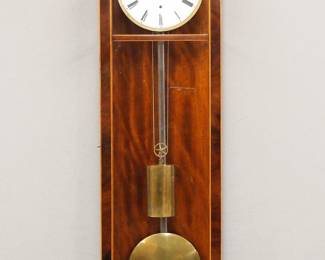 Lot 95: A 19th century Biedermeier Period Vienna Regulator wall clock.  30-day weight driven time only movement with a flat porcelain dial, Roman numerals and engine turned Brass bezel, Steel pendulum rod and Brass bob.  Early Six glass Mahogany case with Satinwood stringing features an arched crest over a molded crown, single long door with square dial glass and rectangular lower above a shaped drop with arched finial.  Polished finish with minor restoration, flaking at winding arbor, running when cataloged.  40 1/2" high overall.  ESTIMATE $1,000-2,000
