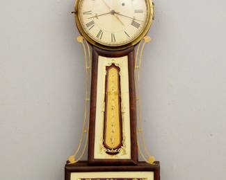 Lot 96: An early 19th century American Banjo clock with alarm.  8-day Brass, weight driven time and alarm movement with exterior top mounted alarm bell, painted Iron dial with Roman numerals.  Mahogany case with pierced Brass arms, Brass dial door with convex glass over reverse painted throat and lower door glasses.  Older finish with wear, crack in throat glass, lacks bell hammer, running when cataloged.  32 1/2" high overall.  ESTIMATE $1,000-2,000
