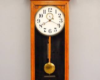 Lot 98: A late 19th century Gilbert No. 14 Regulator wall clock.  8-day weight time only movement with dead beat escapement, maintaining power and a papered metal dial with Arabic numerals and subsidiary seconds.  Oak case with shaped crest and press carved detail over a single molded door and shaped bracket drop.  Older finish with minor wear, lacks some of the beaded case detail, running when cataloged.  49" high overall.  ESTIMATE $1,000-1,500
