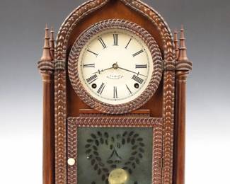 Lot 111:  A mid 19th century Ripple Front Gothic shelf clock by J. C. Brown, Forestville, Conn.  8-day Brass, spring driven time and strike movement with painted metal dial.  Rosewood Onion top case with applied Ripple moldings, four turned finials and columns and a single conforming door with etched lower glass.  Old finish with some wear, re-painted dial, replaced finials, running when cataloged.  19 1/2" high overall.  ESTIMATE $800-1,200
