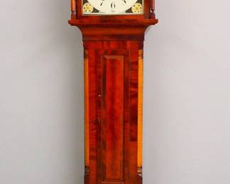 Lot 119:  An early 19th century Pennsylvania Tall clock.  8-day time and strike movement with painted Iron dial and upper moon phase with Arabic numerals, marked "Jno Wood, Philadelphia".  Mahogany case with a broken arch crest over a shaped dial door flanked by turned columns, over a paneled waist door flanked by Curly Maple quarter columns and a base with flared feet.  Older refinishing with minor wear, lacks finials, dial touch-ups, running when cataloged.  103 1/2" high overall.  ESTIMATE $1,000-1,500
