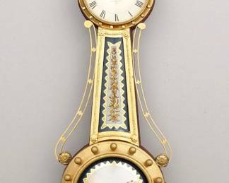 Lot 128:  A late 20th century reproduction L. Curtis Girandole Banjo wall clock.  8-day weight driven time only movement with a painted metal dial and Roman numerals marked "L. Curtis Patent, Concord, Mass, 1818".  Shaped case with Mahogany body and Gilded front having a carved Eagle finial above circular Brass upper door with applied Brass spheres and convex glass over a bowed throat glass with reverse painted decoration flanked by Brass side arms over a circular lower door with wood spheres, convex glass and reverse painted Wharf scene and a carved foliate drop.  Minor case and finish wear and variation, the throat frame is much lighter and may have been cleaned or re-Gilded, not running when cataloged.  46 1/2" high overall.  ESTIMATE $1,000-1,500
