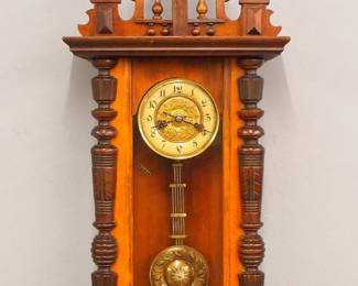 Lot 132: A turn of the century Junghans wall clock with music box.  8-day spring driven movement with celluloid chapter ring, Roman numerals, embossed Brass dial center and matching gridiron pendulum.  Walnut case with galleried "Horse" crest over a single door with arched glass flanked by turned pilasters, and a shaped lower drop.  Old finish with minor wear, running when cataloged.  41" high overall.  ESTIMATE $800-1,200
