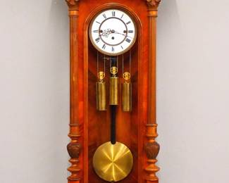 Lot 137: A late 19th century Vienna Regulator wall clock with "REMEMBER" trademark by the Resch Brothers Clock Factory in Ebensee, Austria.  8-day weight driven time and strike movement with quarter hour Grand Sonnerie chime and two part porcelain dial with Roman numerals and molded Brass bezel, serial #58923.  Altdeutsch Style Walnut case with an arched carved crest over a single long door with arched glass flanked by fluted pilasters with carved detail over a shaped drop.  Older finish with some wear and minor damage, replaced finials, dial hairlines, running when cataloged.  51" high overall.  ESTIMATE $800-1,200
